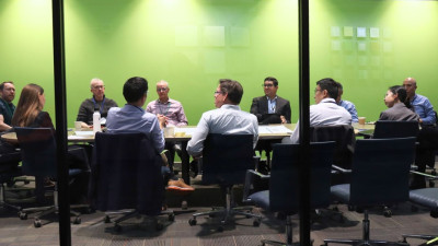Duke personnel sit in a green room, discussing research.