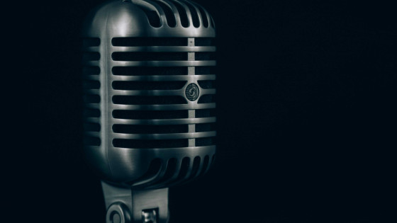 A microphone over a black background.